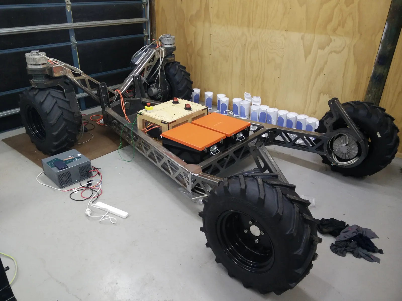 The chassis in the workshop with all four wheels mounted, before cabinetry